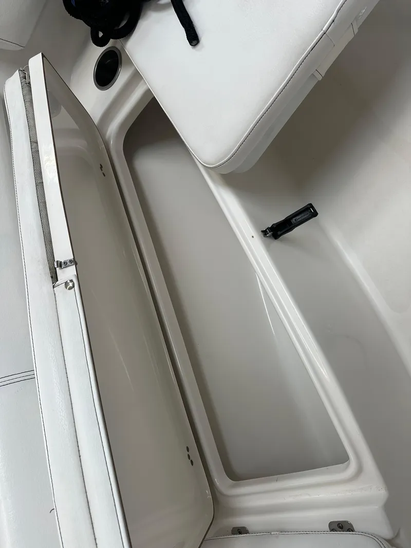 Slide: The Image of 2020 Sea Pro 259 Center Console boat storage compartment with white cushioned seating. - 18