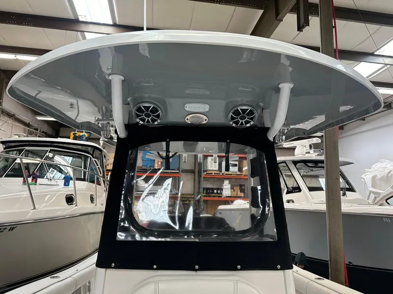 Slide: The Image of 2020 Sea Pro 259 Center Console boat with T-top and speakers in a showroom. - 20