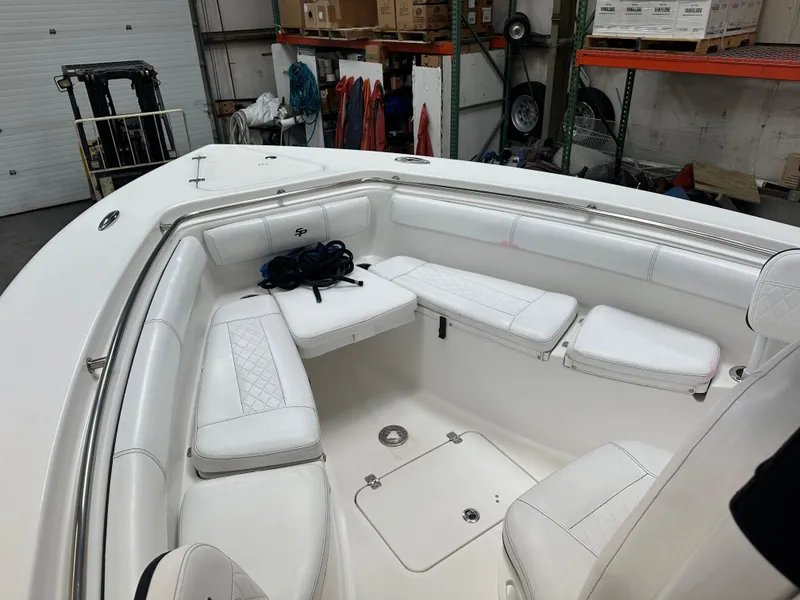 Slide: The Image of 2020 Sea Pro 259 Center Console boat interior with white seating in a warehouse. - 22