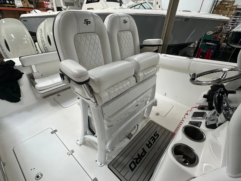 Slide: The Image of 2020 Sea Pro 259 Center Console boat interior with dual white cushioned seats and console. - 6