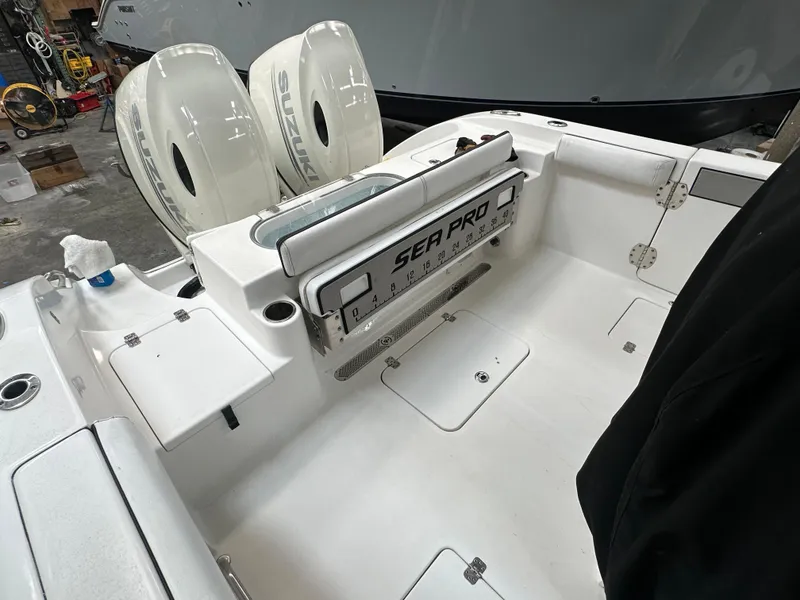 Slide: The Image of 2020 Sea Pro 259 Center Console boat interior with dual engines in a garage setting. - 9