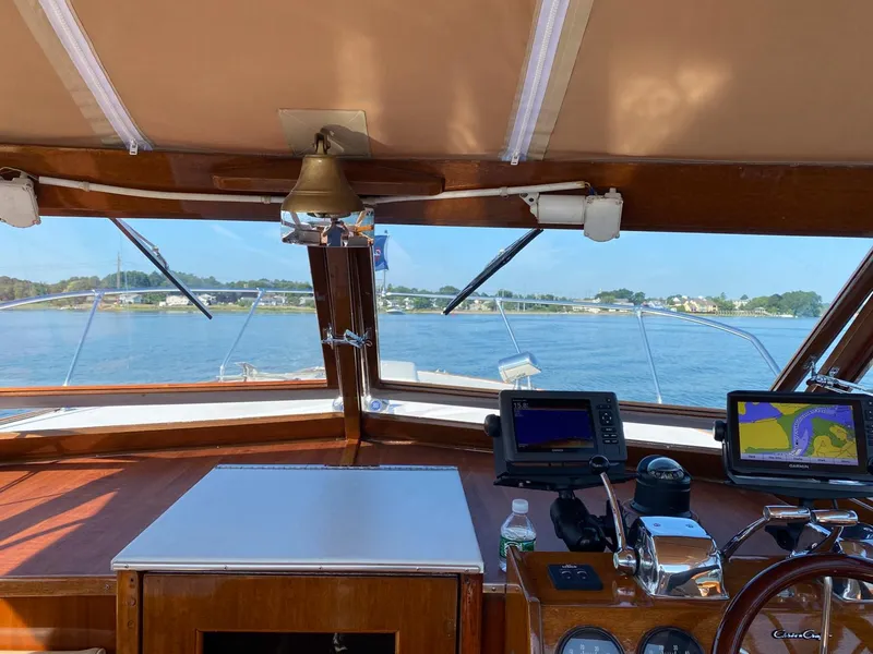 Slide: The Image of 1973 Chris-Craft Sport Deck interior with navigation equipment, overlooking serene waters and distant shoreline. - 10