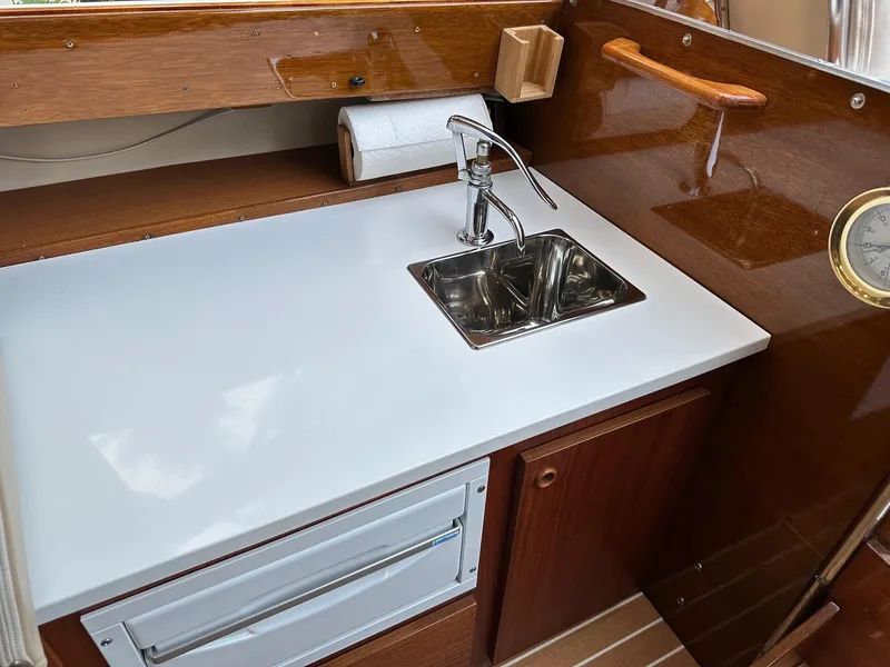 Slide: The Image of 1973 Chris-Craft Sport Deck boat interior with sink and wooden cabinetry. - 12