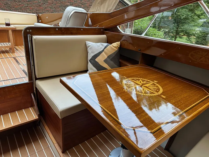 Slide: The Image of 1973 Chris-Craft Sport Deck interior with polished wood table and cushioned seating. - 13