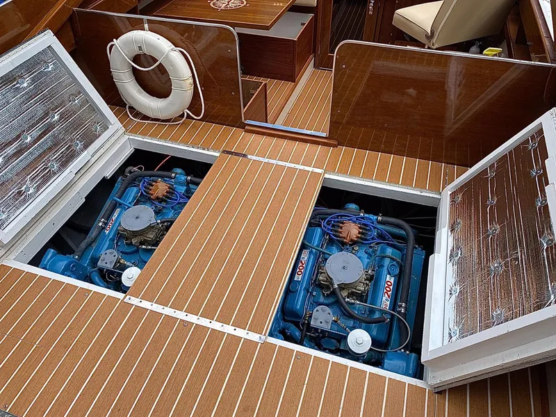 Slide: The Image of 1973 Chris-Craft Sport Deck boat engine compartment with twin engines and wooden deck. - 17