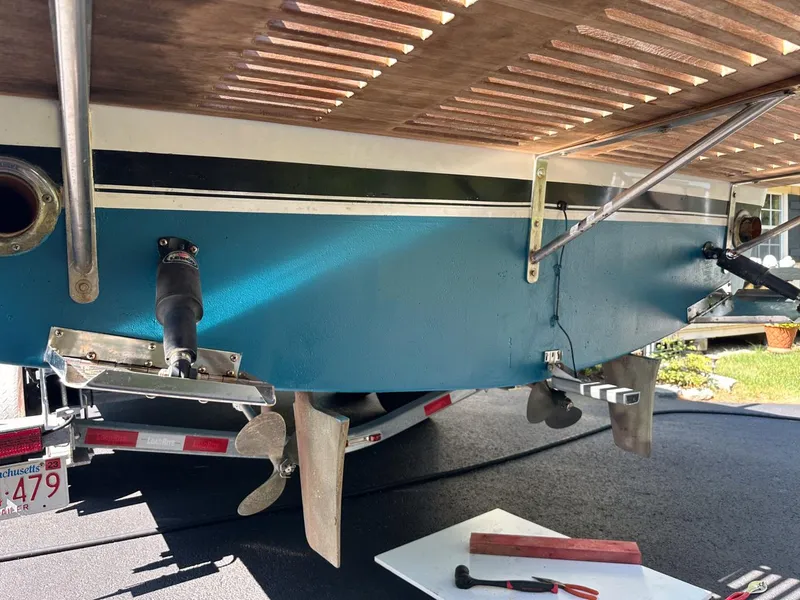 Slide: The Image of 1973 Chris-Craft Sport Deck boat on trailer, showing propeller and hull details. - 8