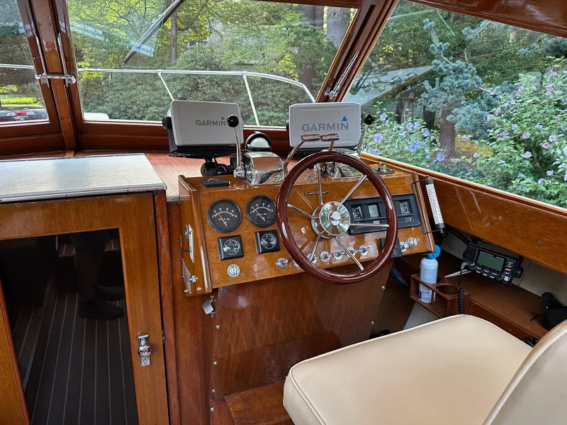 Slide: The Image of 1973 Chris-Craft Sport Deck boat interior with wooden dashboard and Garmin navigation system. - 9