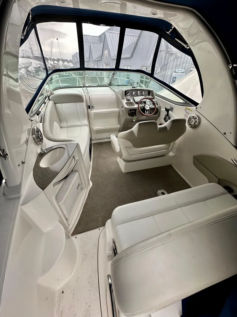 Slide: The Image of 2014 Chaparral 270 Signature boat interior with white seating and modern dashboard. - 11