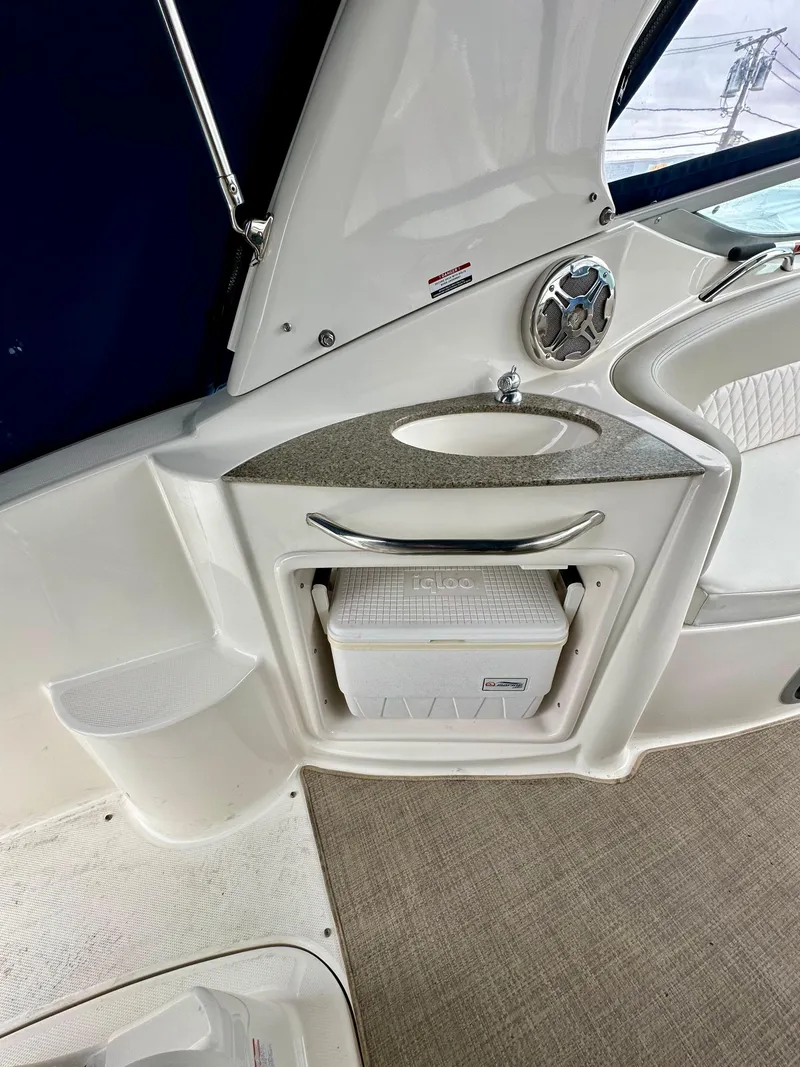 Slide: The Image of 2014 Chaparral 270 Signature boat interior with storage compartment and cooler. - 12