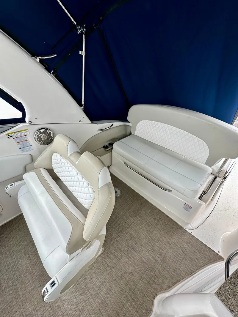 Slide: The Image of 2014 Chaparral 270 Signature boat interior with white seating and blue canopy. - 13