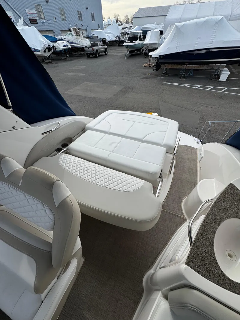 Slide: The Image of 2014 Chaparral 270 Signature boat interior with white seating, docked in a marina. - 25