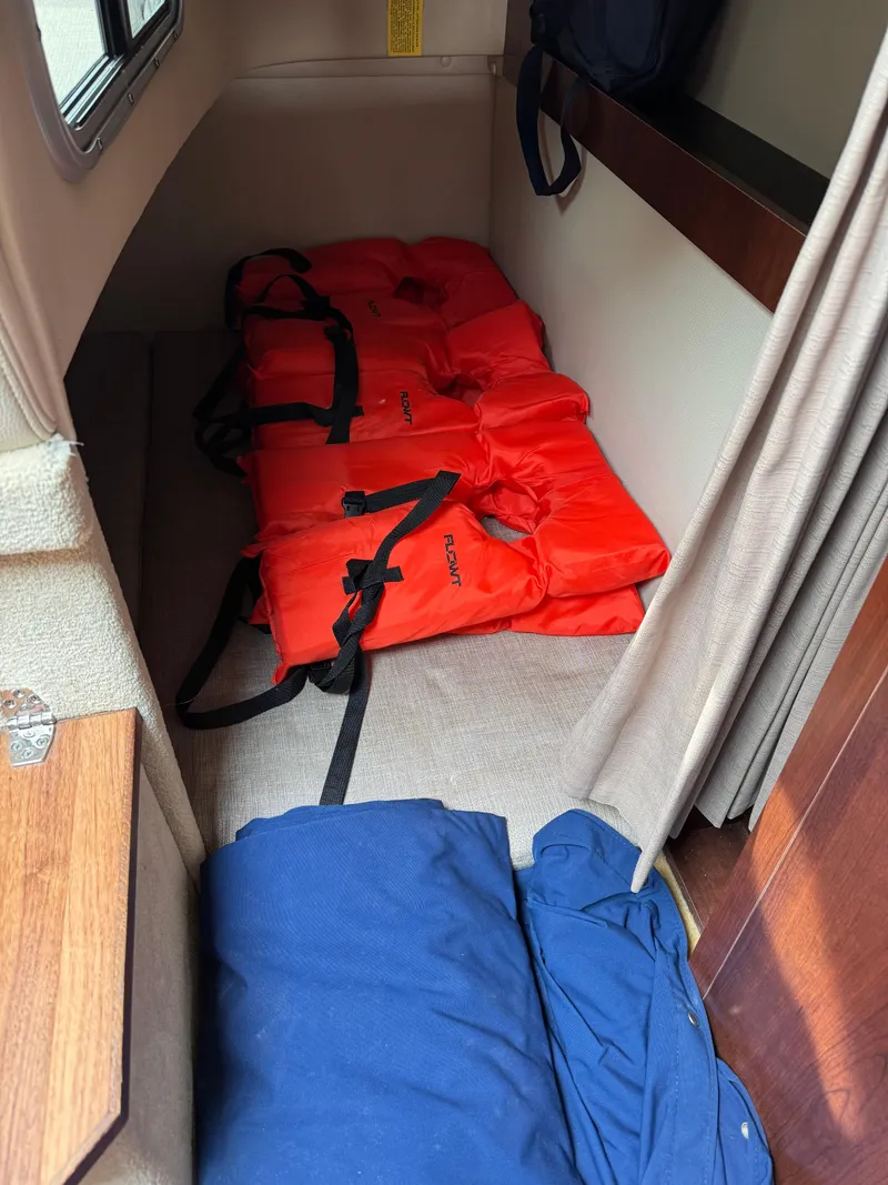 Slide: The Image of Interior cabin of 2014 Chaparral 270 Signature with life jackets and blue bag. - 27