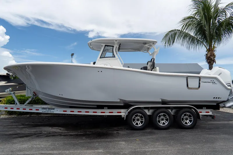 Slide: The Image of 2025 Tidewater 302CC Adventure boat on trailer, parked near palm tree. - 10
