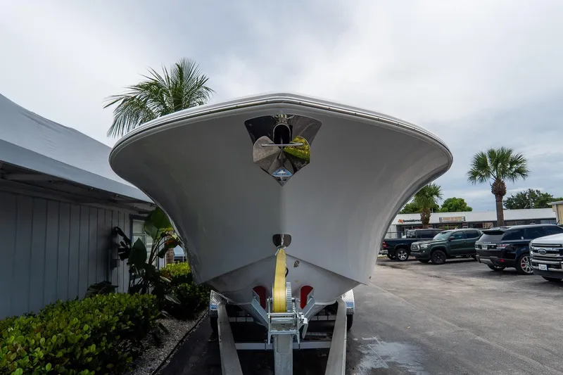 Slide: The Image of 2025 Tidewater 302CC Adventure boat on trailer, parked outdoors with palm trees. - 12