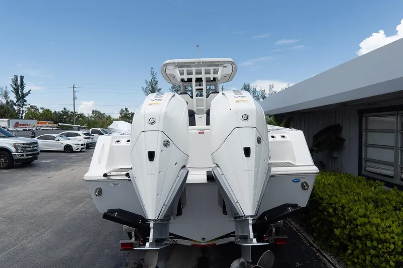 Slide: The Image of 2025 Tidewater 302CC Adventure boat with dual outboard engines, parked outdoors. - 14