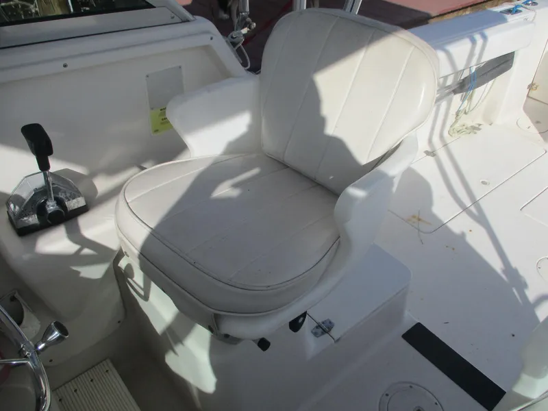 Slide: The Image of 1997 Pro-Line 251 WA boat cockpit with white captain's chair and control lever. - 11