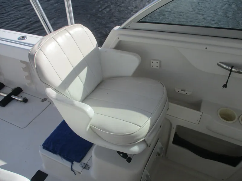 Slide: The Image of White captain's chair on a 1997 Pro-Line 251 WA boat, near water. - 12