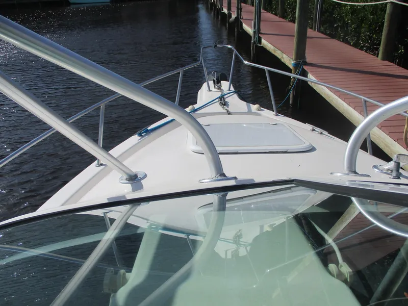 Slide: The Image of 1997 Pro-Line 251 WA boat docked by wooden pier, viewed from the deck. - 19