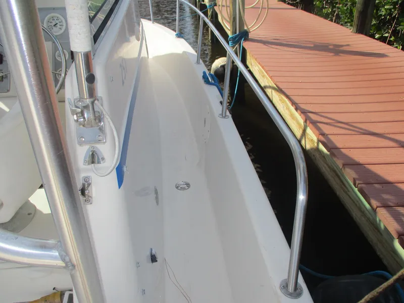 Slide: The Image of 1997 Pro-Line 251 WA boat docked, showing side deck and railing. - 26