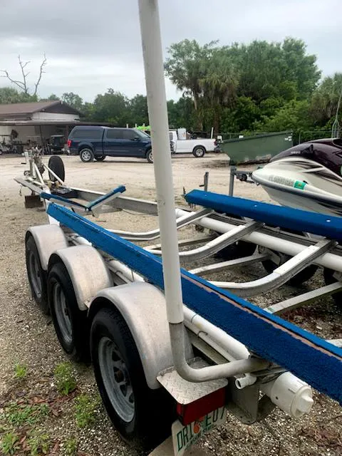 Slide: The Image of 1997 Pro-Line 251 WA boat trailer with triple axles parked outdoors. - 33