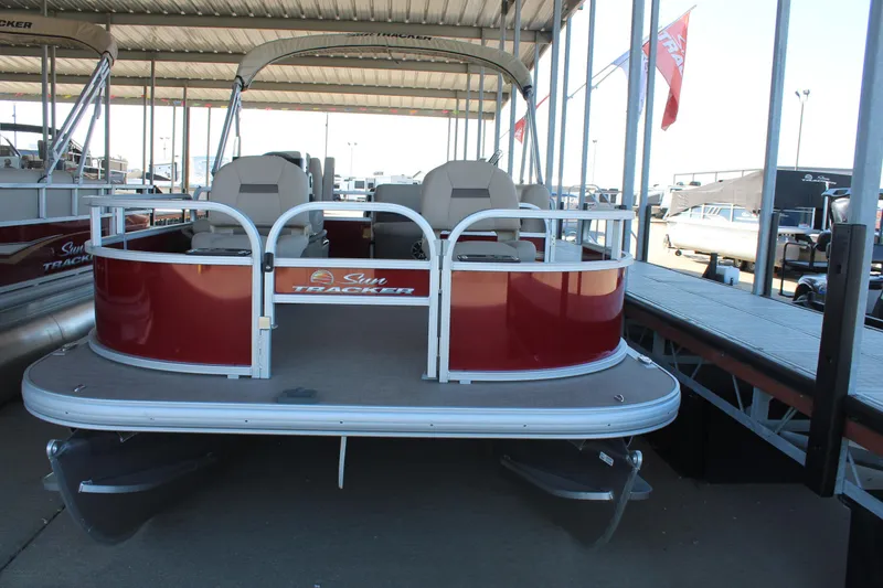 Slide: The Image of 2025 Sun Tracker Bass Buggy 16 XL Select pontoon boat docked under a canopy. - 4
