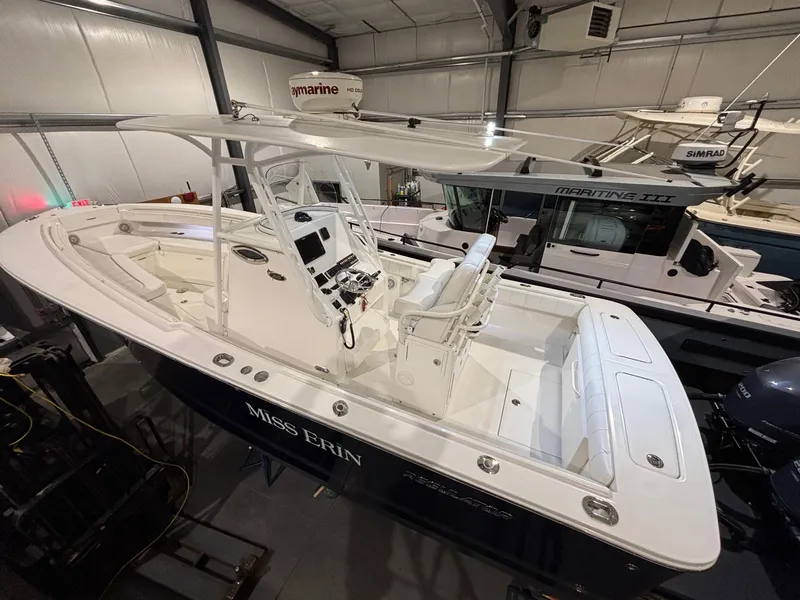 Slide: The Image of 2015 Regulator 25 boat in indoor storage, featuring a sleek design and spacious deck. - 11