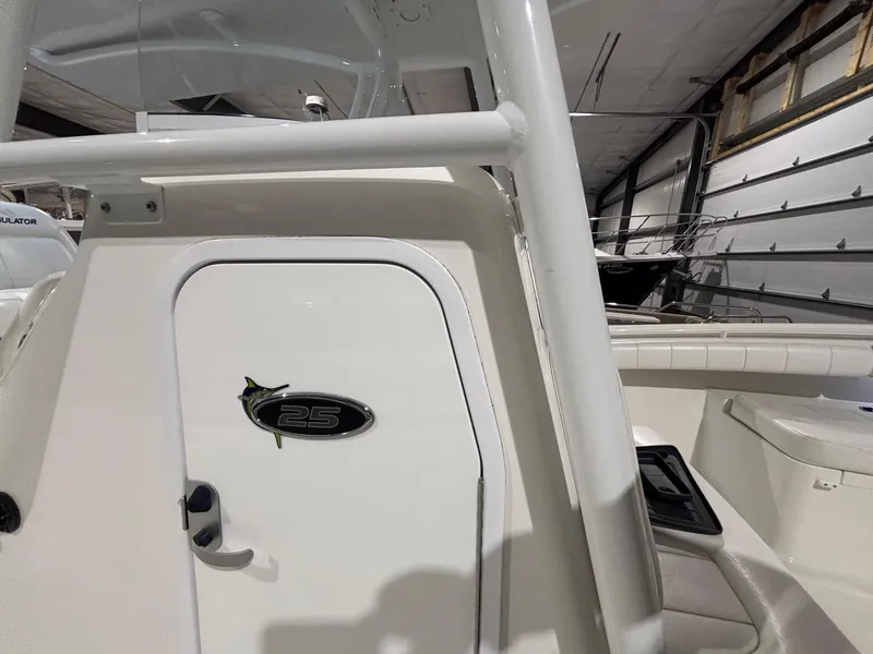 Slide: The Image of 2015 Regulator 25 boat interior, featuring a white cabin door in a garage setting. - 37