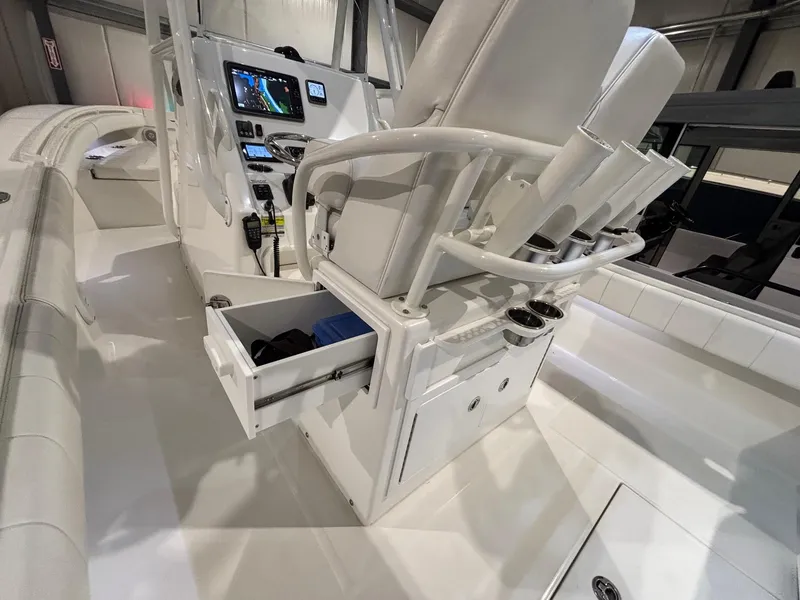 Slide: The Image of 2015 Regulator 25 boat interior with helm, seating, and storage compartments. - 41