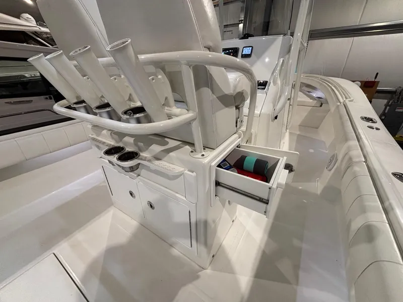 Slide: The Image of 2015 Regulator 25 boat interior with rod holders and storage drawer open. - 43