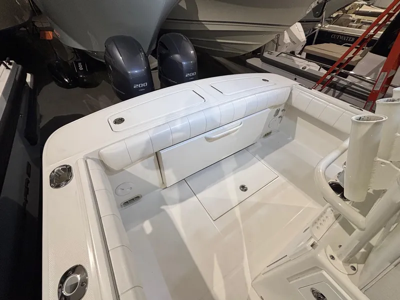 Slide: The Image of 2015 Regulator 25 boat interior with twin 200 engines, white seating, and storage compartments. - 45