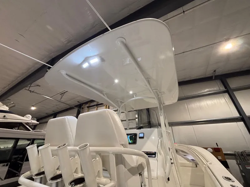 Slide: The Image of 2015 Regulator 25 boat interior with T-top and rod holders in a storage facility. - 46