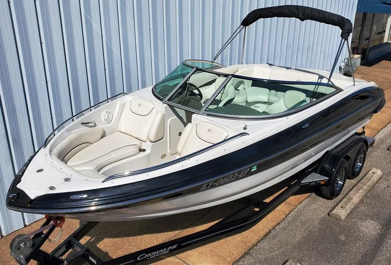 Slide: The Image of 2011 Crownline 230LS BR boat on trailer, sleek design, white and black exterior. - 1