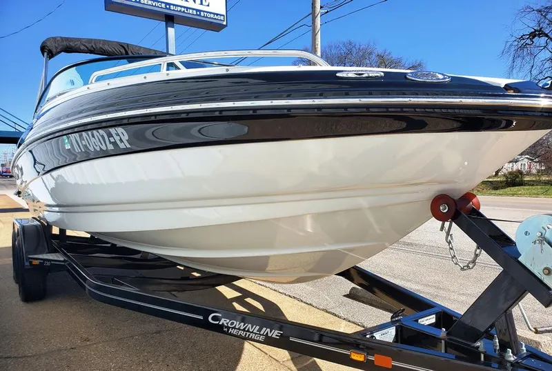 Slide: The Image of 2011 Crownline 230LS BR boat on trailer, black and white design, parked outdoors. - 15