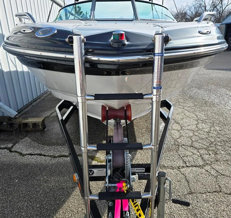 Slide: The Image of 2011 Crownline 230LS BR boat on trailer, front view, parked on pavement. - 16