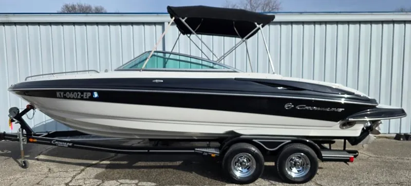 Slide: The Image of 2011 Crownline 230LS BR boat on trailer, black and white design, parked outdoors. - 17