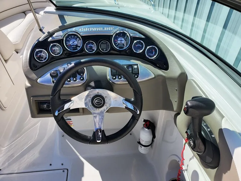 Slide: The Image of 2011 Crownline 230LS BR boat dashboard with steering wheel and control panel. - 23