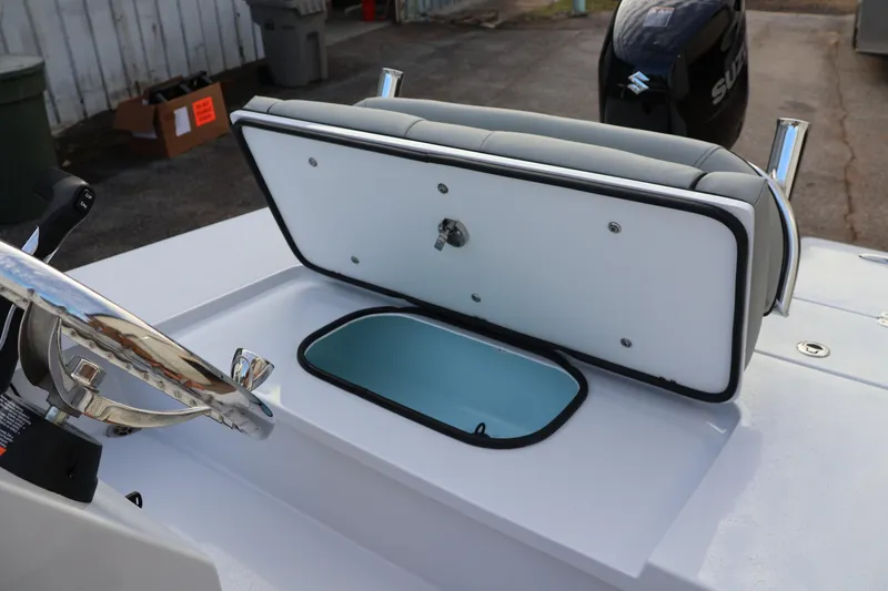 Slide: The Image of 2025 Custom Texar Flats Hybrid 16 boat interior with open storage compartment and steering wheel. - 5