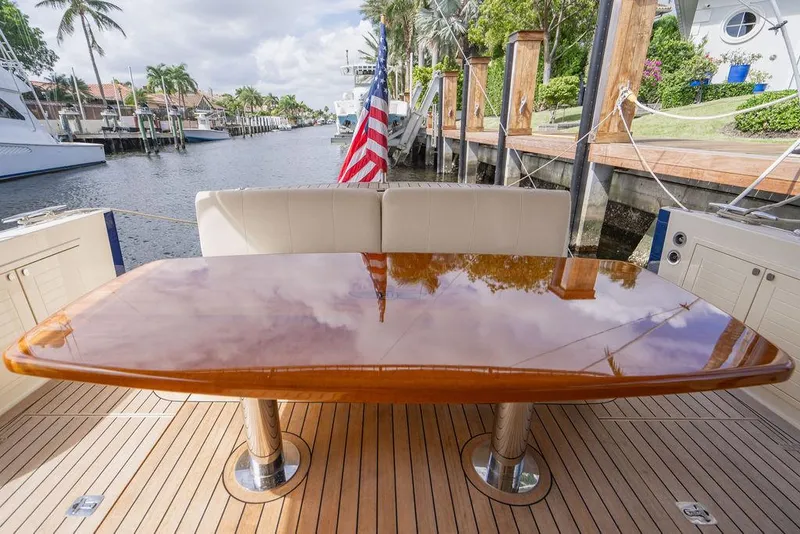 Slide: The Image of 2015 Palm Beach Motor Yachts PB52, polished table, docked by a scenic canal. - 18