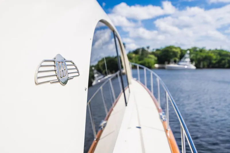 Slide: The Image of 2015 Palm Beach Motor Yachts PB52 cruising on a serene lake under a blue sky. - 23