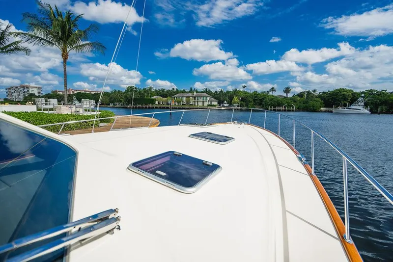 Slide: The Image of 2015 Palm Beach Motor Yachts PB52 on scenic waterway with blue sky and palm trees. - 24