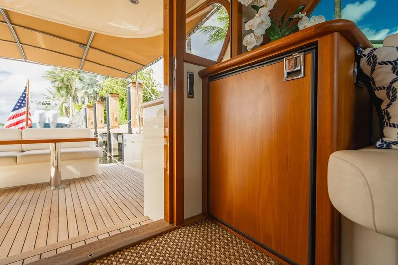 Slide: The Image of Interior view of 2015 Palm Beach Motor Yachts PB52, featuring elegant wood finishes and outdoor seating. - 27