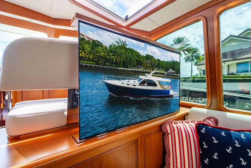 Slide: The Image of Interior of 2015 Palm Beach Motor Yachts PB52 with a TV displaying a yacht image. - 34