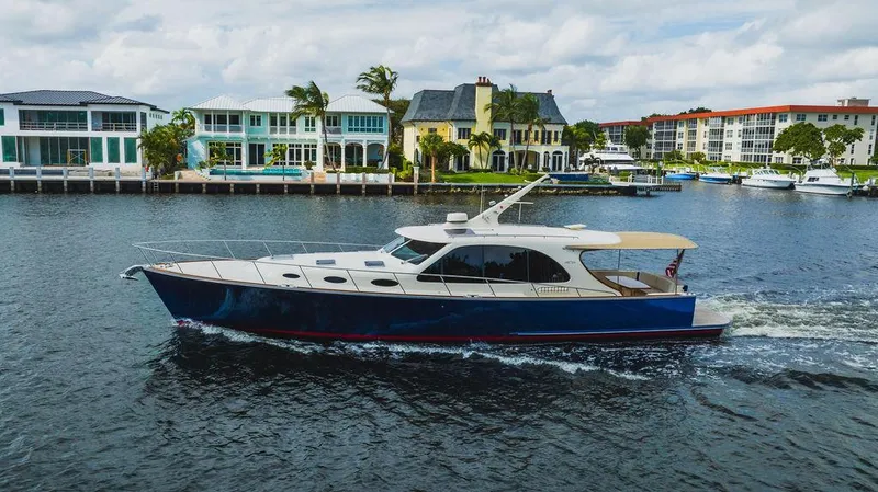 Slide: The Image of 2015 Palm Beach Motor Yachts PB52 cruising near waterfront homes. - 4