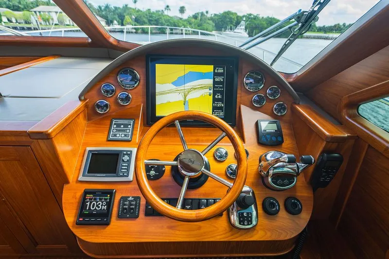 Slide: The Image of 2015 Palm Beach Motor Yachts PB52 helm with navigation display and wooden steering wheel. - 44