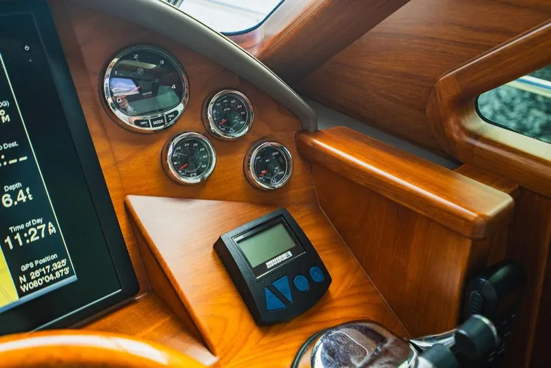 Slide: The Image of Control panel of 2015 Palm Beach Motor Yachts PB52 with wooden finish and gauges. - 46