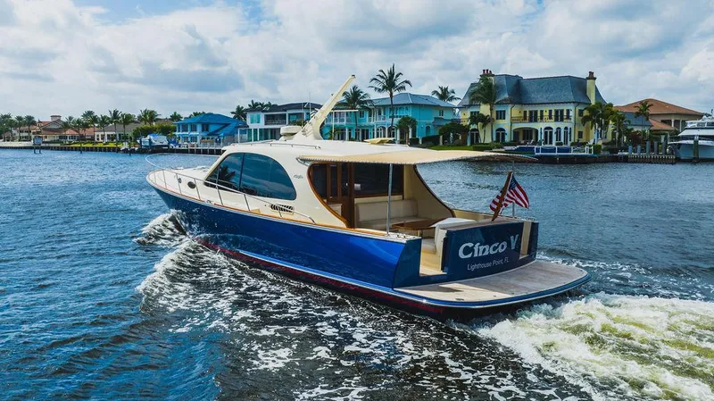 Slide: The Image of 2015 Palm Beach Motor Yachts PB52 cruising near colorful waterfront homes. - 9