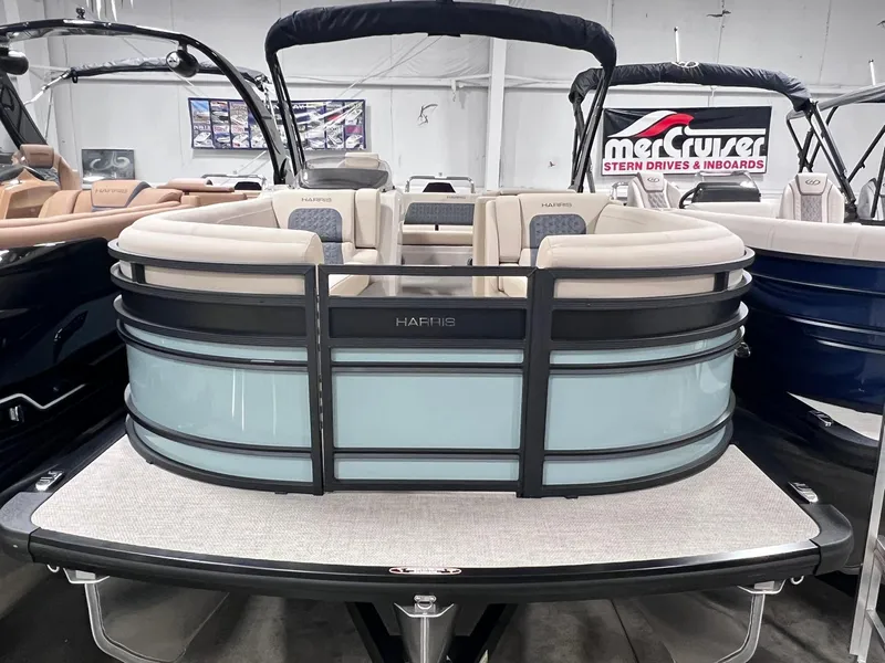 Slide: The Image of 2025 Harris Solstice 250 pontoon boat in showroom, featuring sleek design and comfortable seating. - 2