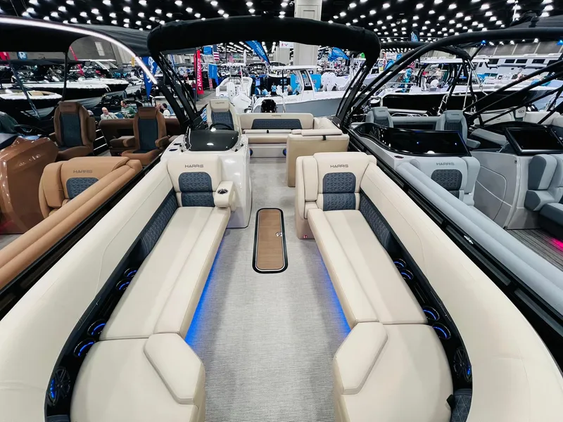 Slide: The Image of 2025 Harris Solstice 250 boat interior with luxurious seating and modern design at a boat show. - 4