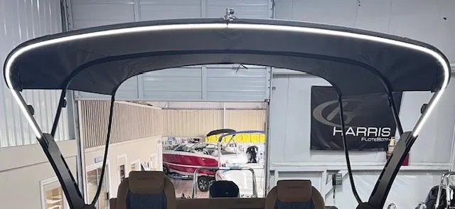 Slide: The Image of 2025 Harris Solstice 250 boat with illuminated canopy in showroom. - 5