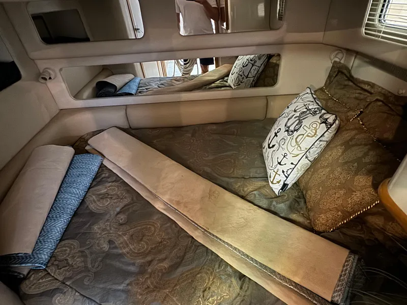 Slide: The Image of Cozy cabin interior of 1995 Sea Ray 450 Sundancer with nautical-themed bedding. - 13